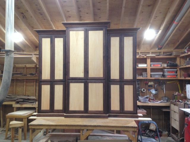 Finished wooden cabinet with light panels and dark trim in a workshop.