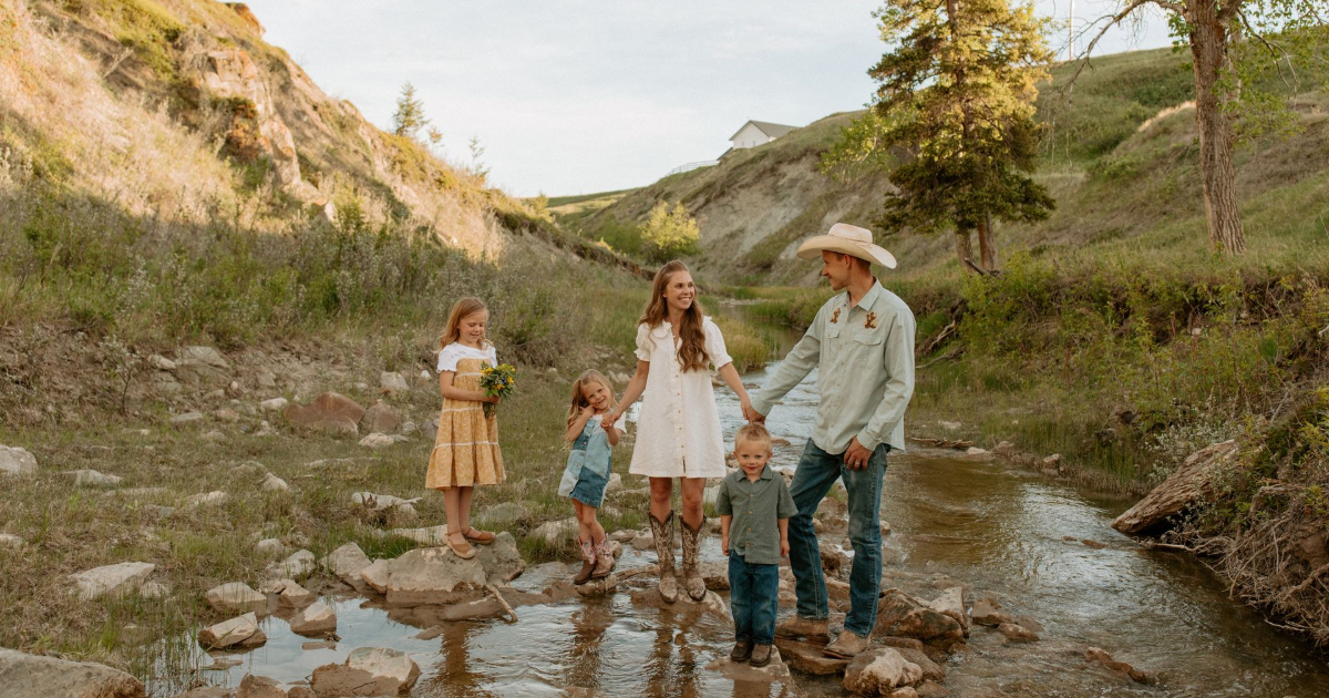 An Alberta rancher family standing in a creek