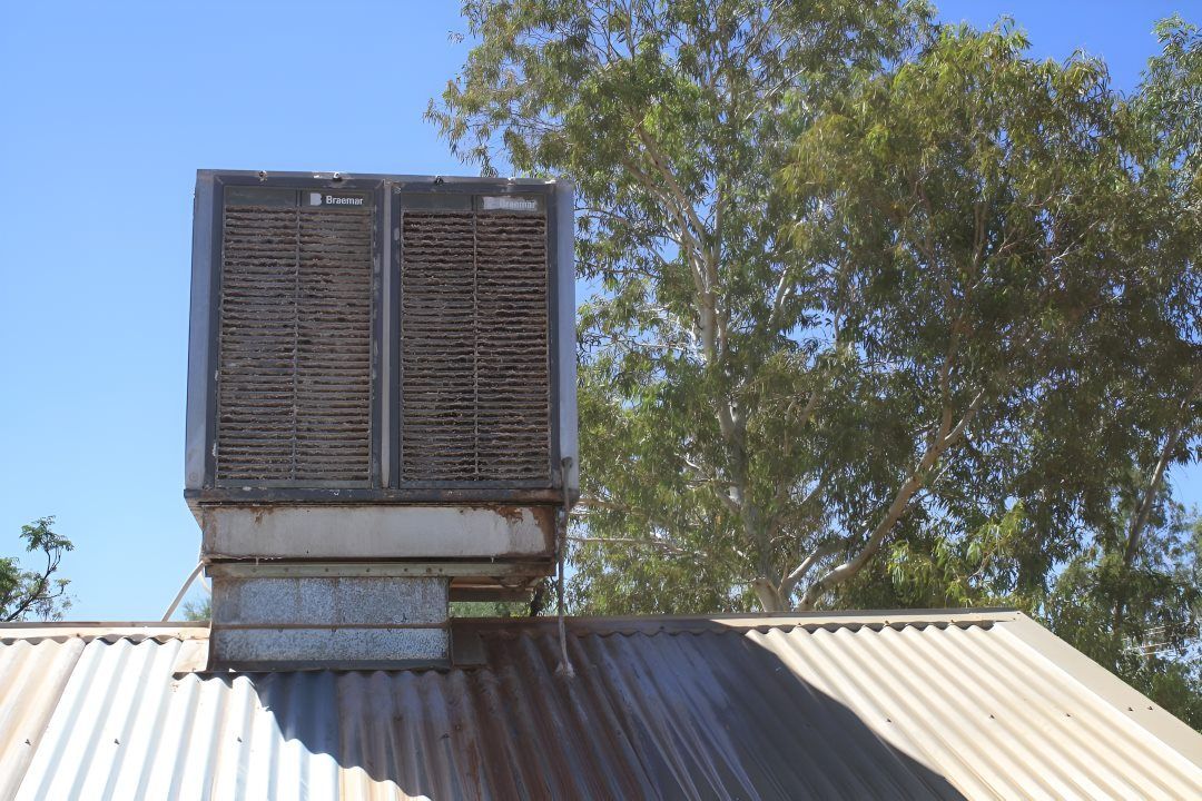 A Large Air Conditioner is Sitting on Top of a Roof —​ Centre Evap & Home Maintenance Services in Ciccone, NT