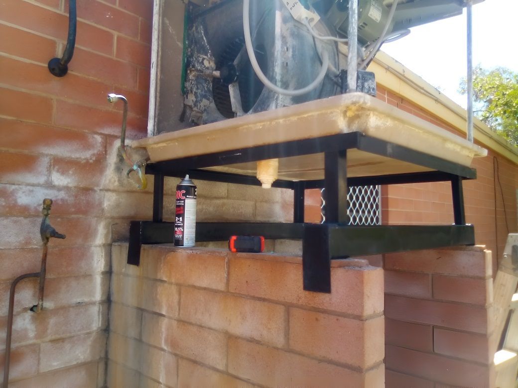 A Brick Wall With a Metal Shelf on Top of It —​ Centre Evap & Home Maintenance Services in Ciccone, NT