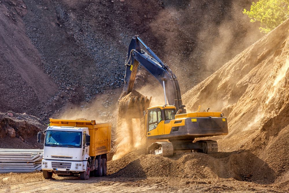 A Yellow Excavator Loading a White Dump Truck With Dirt — GA Plant & Automotive Repairs In Taminda, NSW