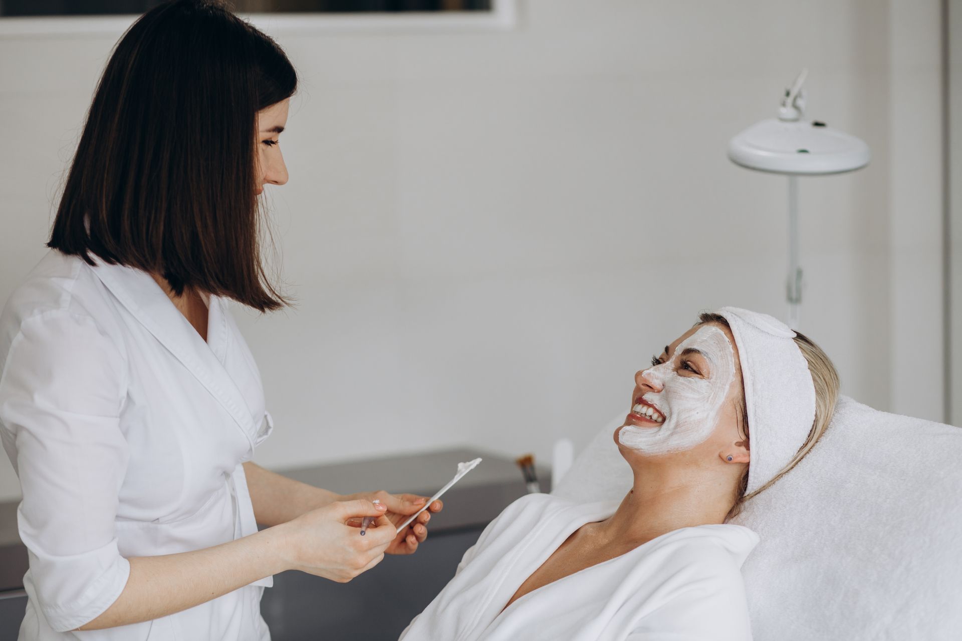 A woman is getting a facial treatment at a beauty salon.
