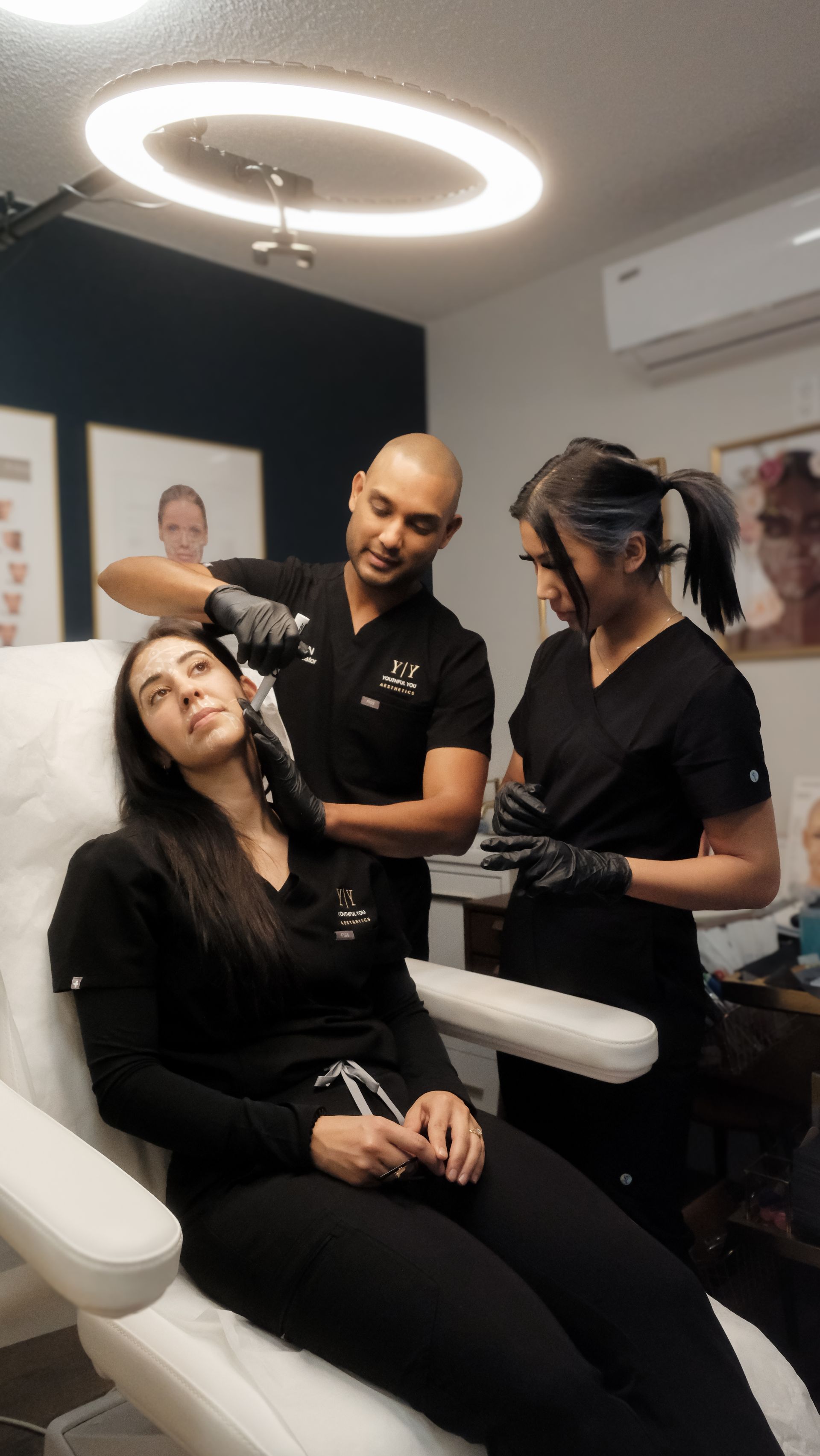 two women are working on a woman 's eyebrows in a salon .
