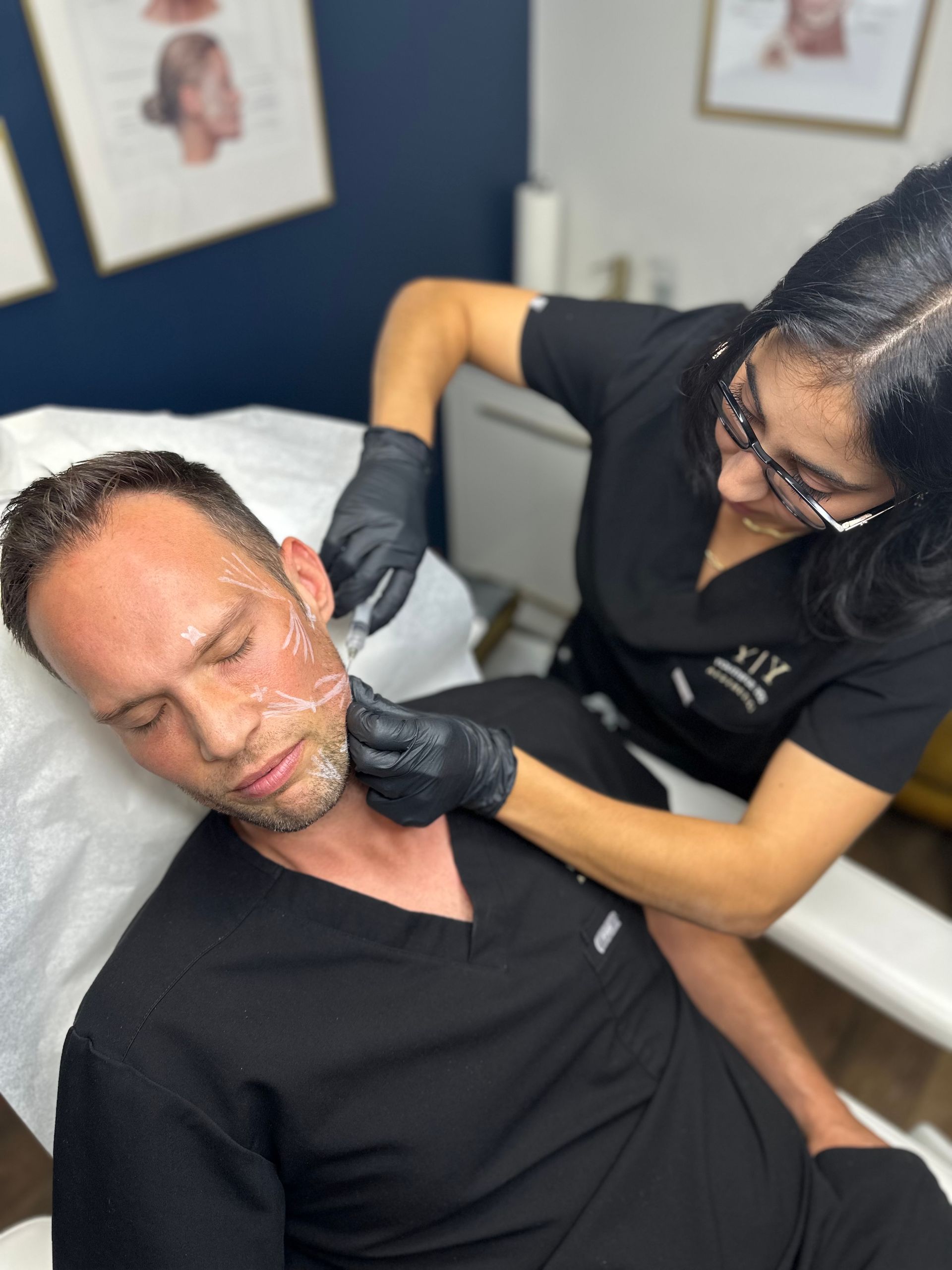 a woman is giving a man a botox treatment on his face .