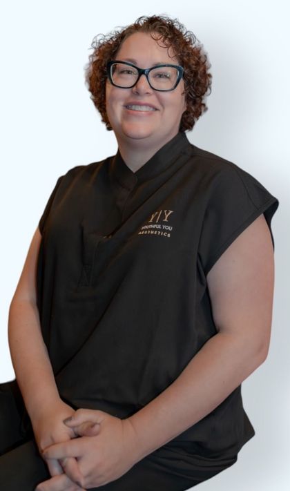 A woman wearing glasses and a black shirt is smiling for the camera.