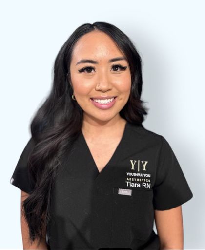 A woman wearing a black scrub top that says ' y / y ' on it