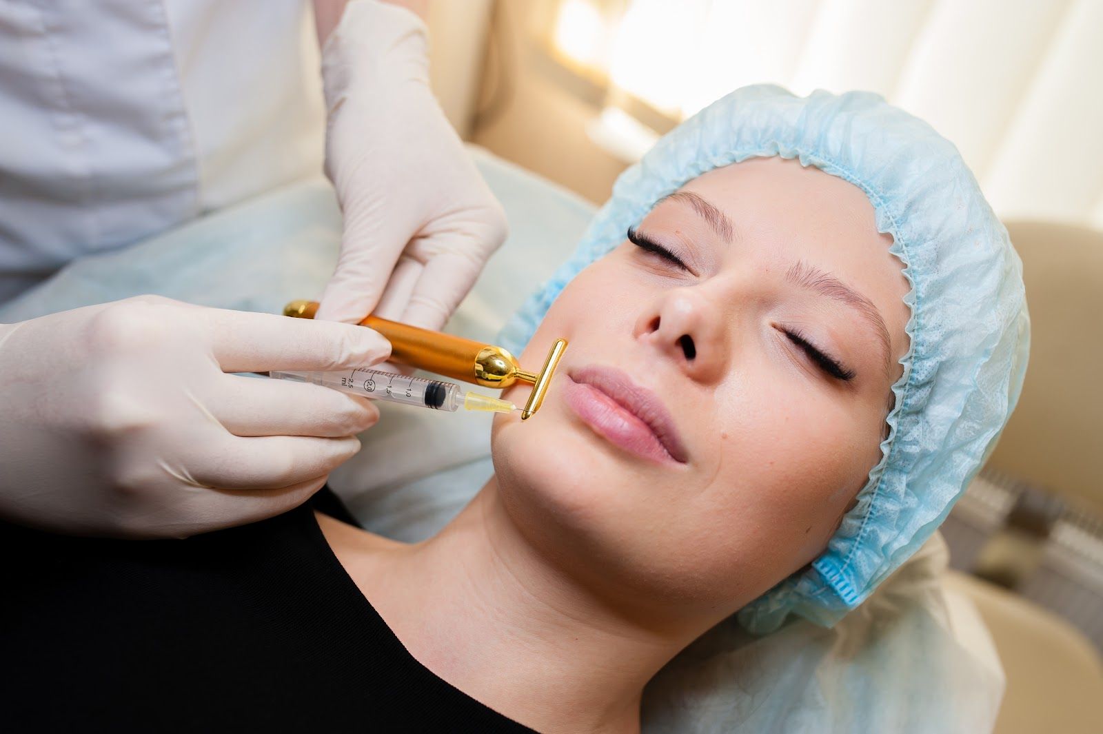 Person receiving lip filler injections; medical professional in gloves injecting lip area.