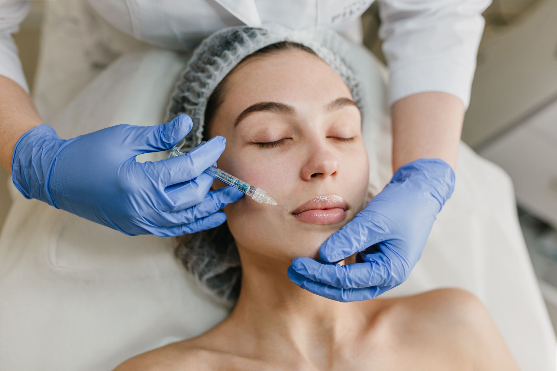 A woman is getting a botox injection in her face.