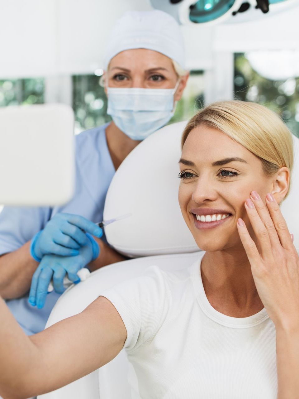 A woman is smiling while sitting in a dental chair.