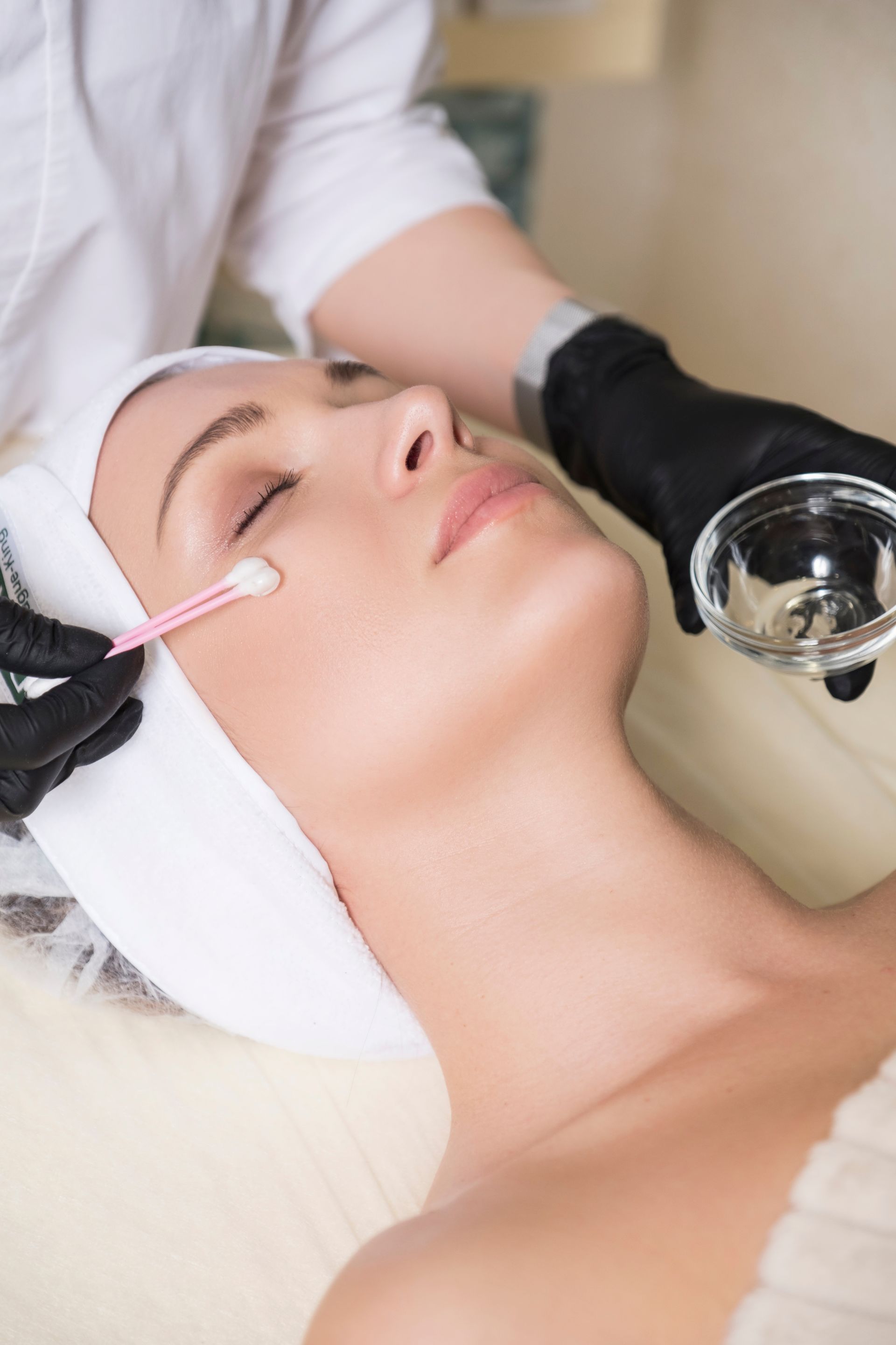 A woman is getting a facial treatment at a beauty salon.