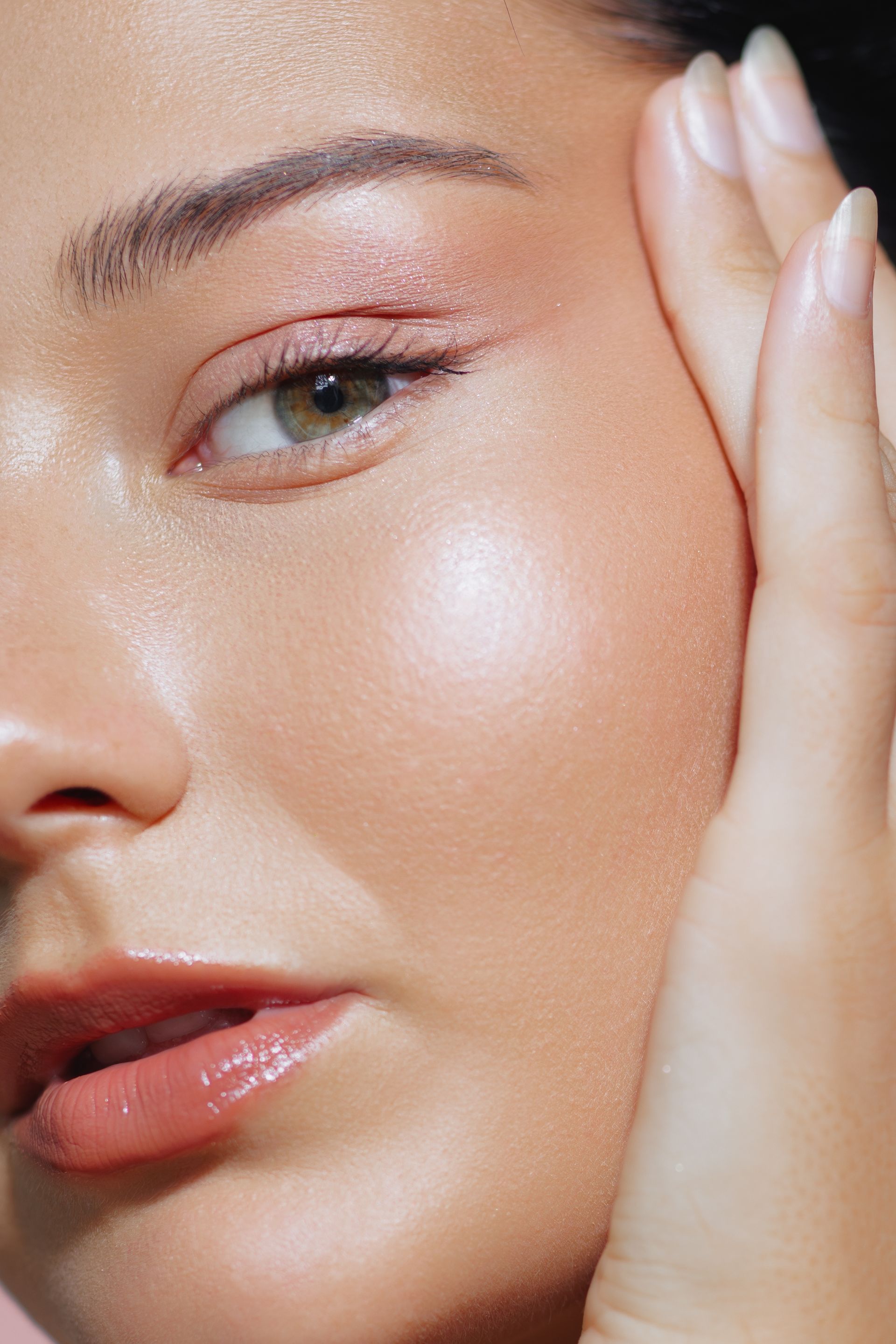 A close up of a woman 's face with her hand on her face.