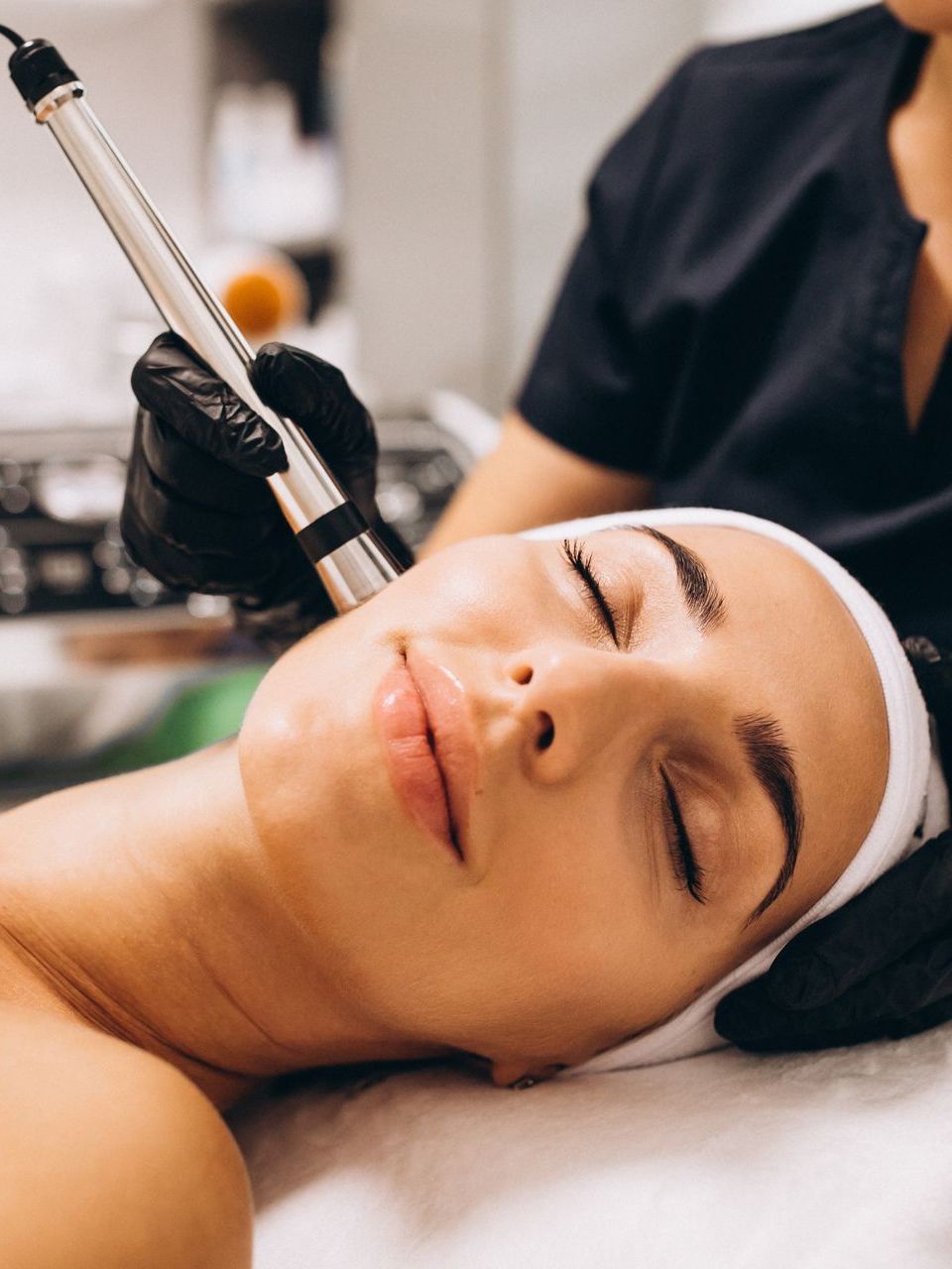 a woman is getting a facial treatment with her eyes closed