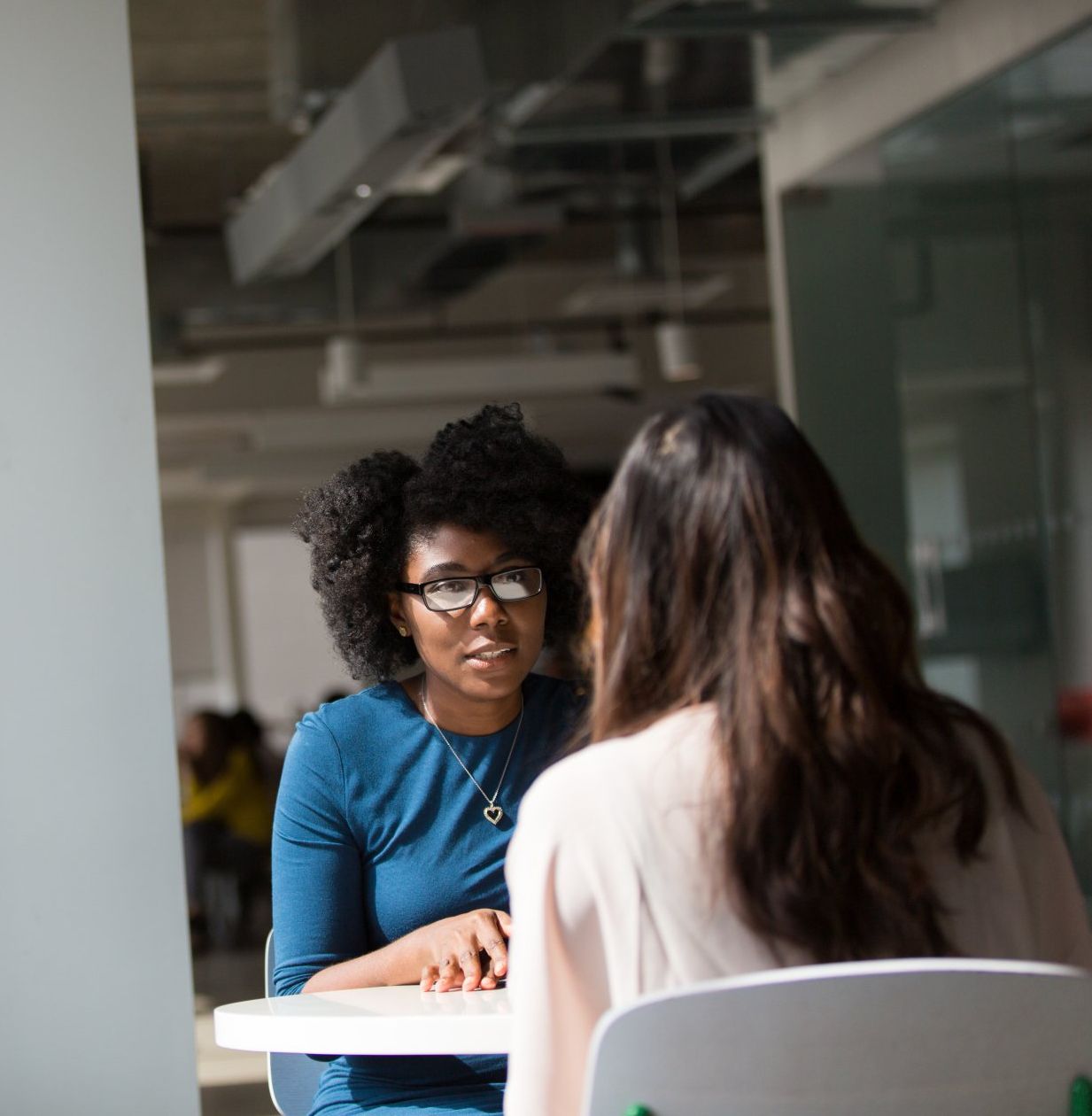 photo of two women having a conversation around a table