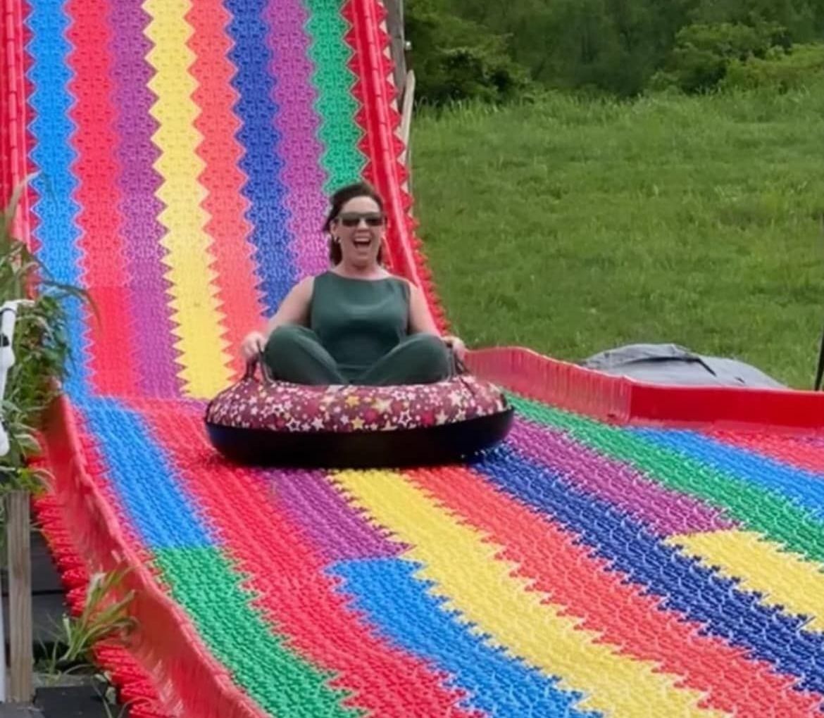 A woman is riding a mega tube slide at river city adventure park