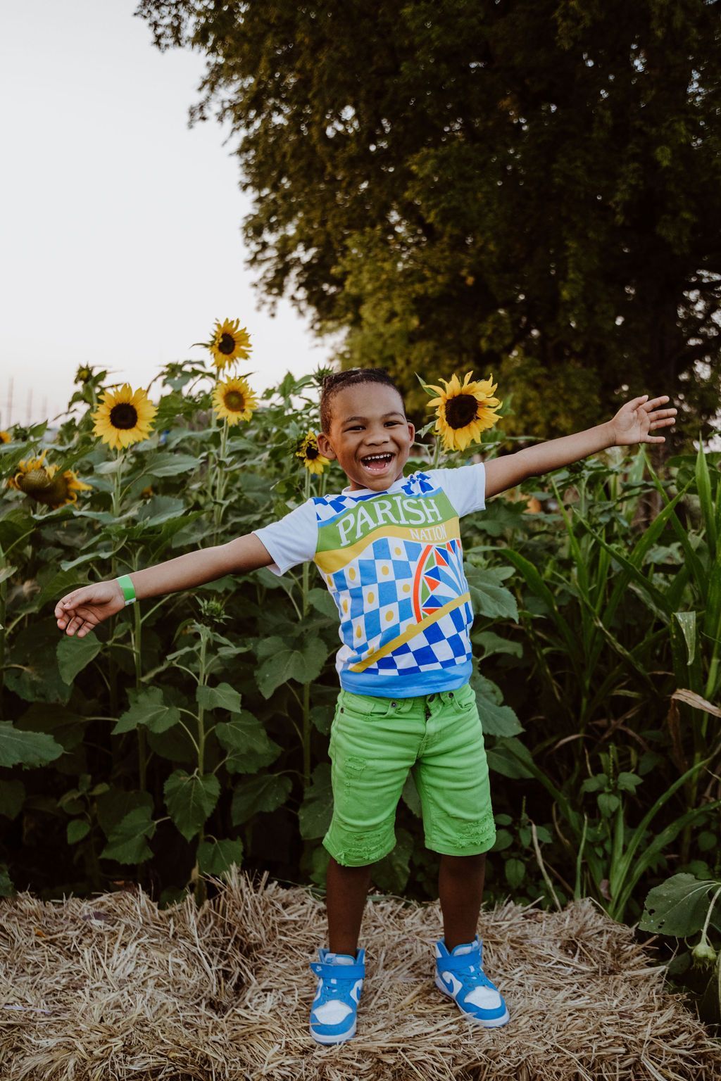 A woman in a hat is standing in a field of sunflowers.