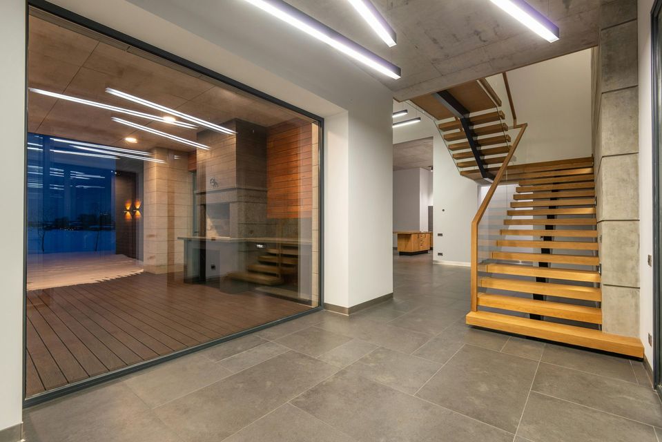 An empty room with a wooden staircase and a large window