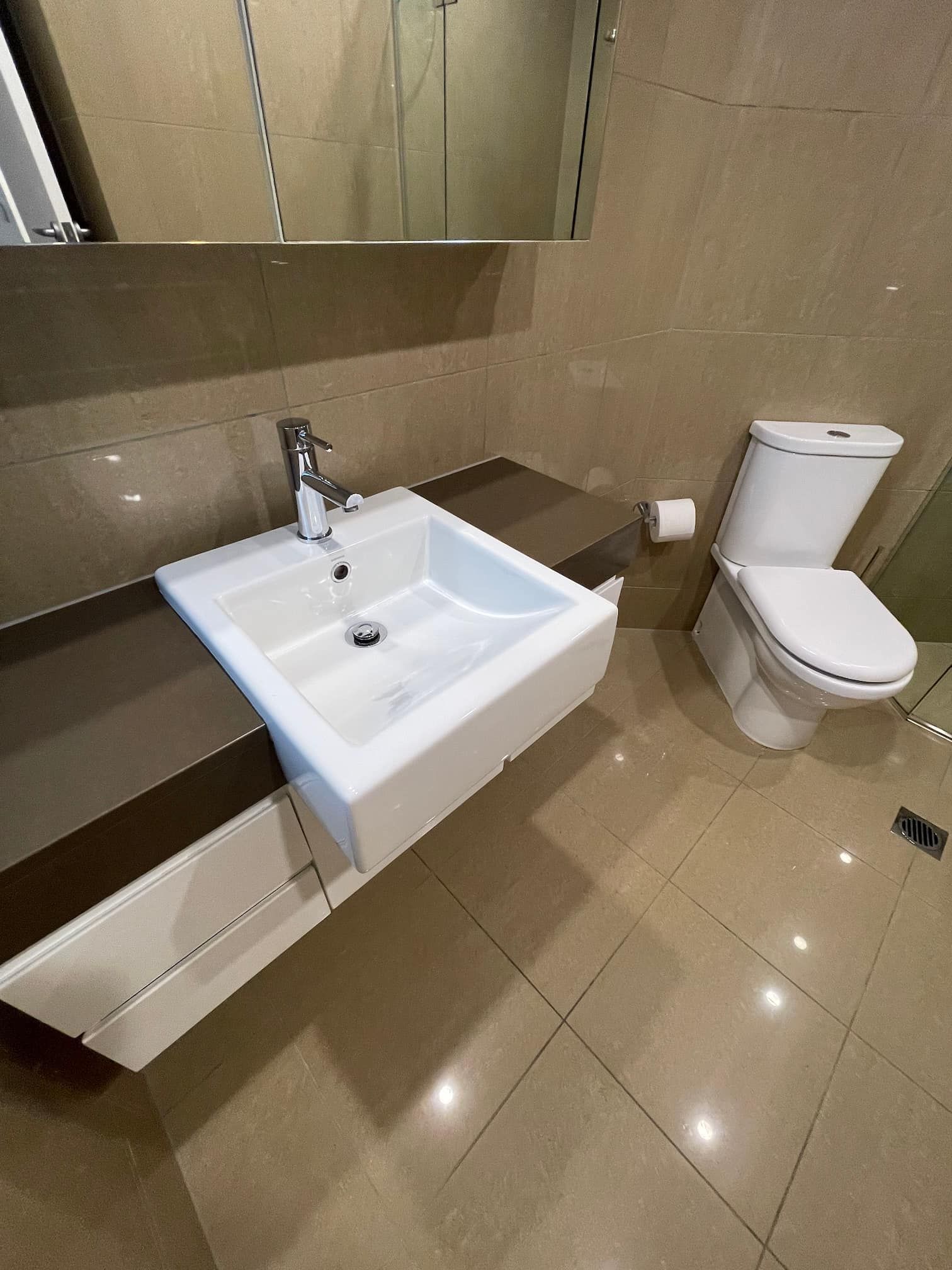 Bathroom with a white sink, toilet, and neutral-toned walls and floor.