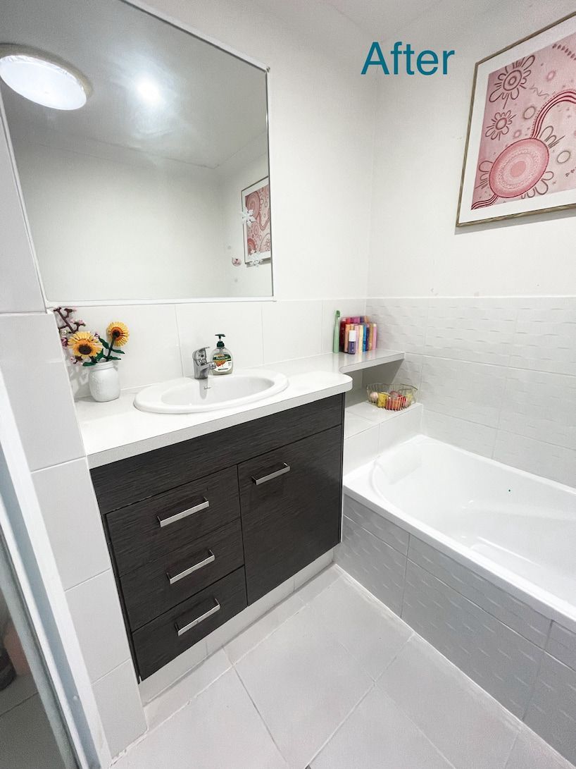 Bathroom with a dark brown vanity, white countertop, mirror, and tub;
