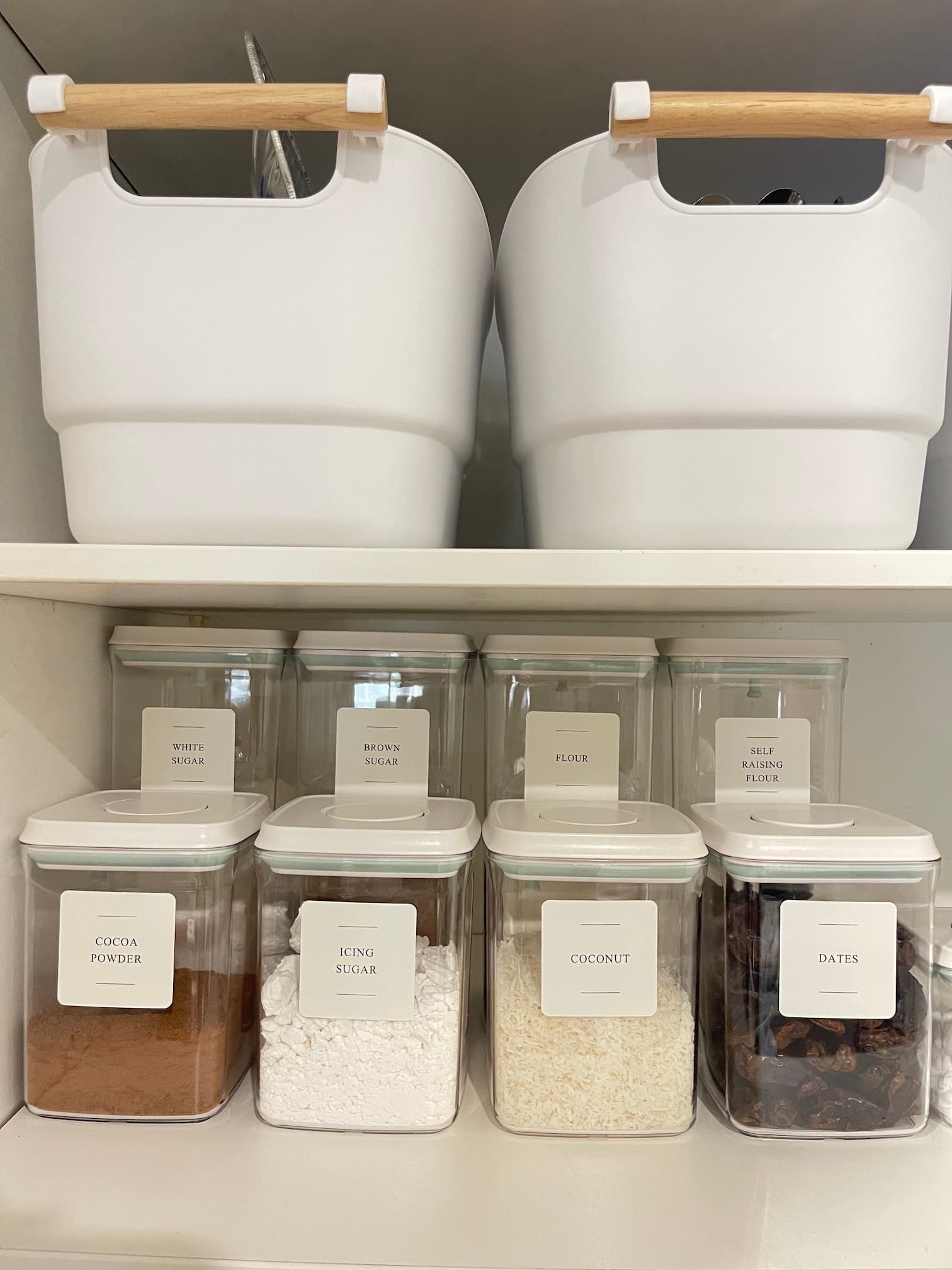 Organized pantry shelf with white containers.