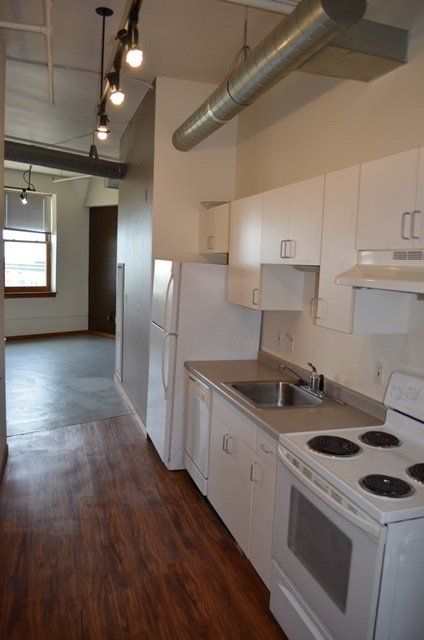 Kitchen with stove and refrigerator and view of living room.