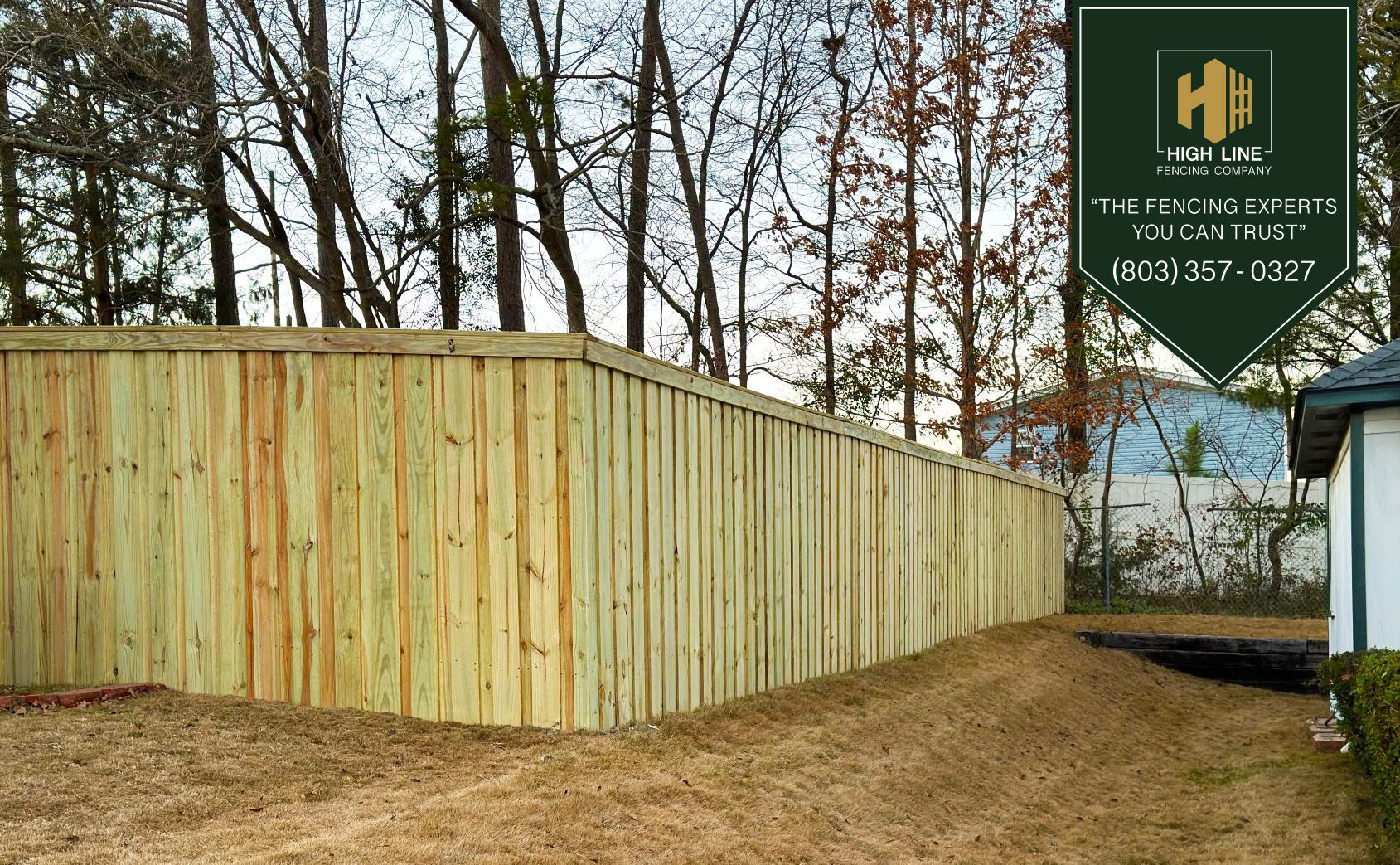 A wooden fence is sitting in front of a brick building.