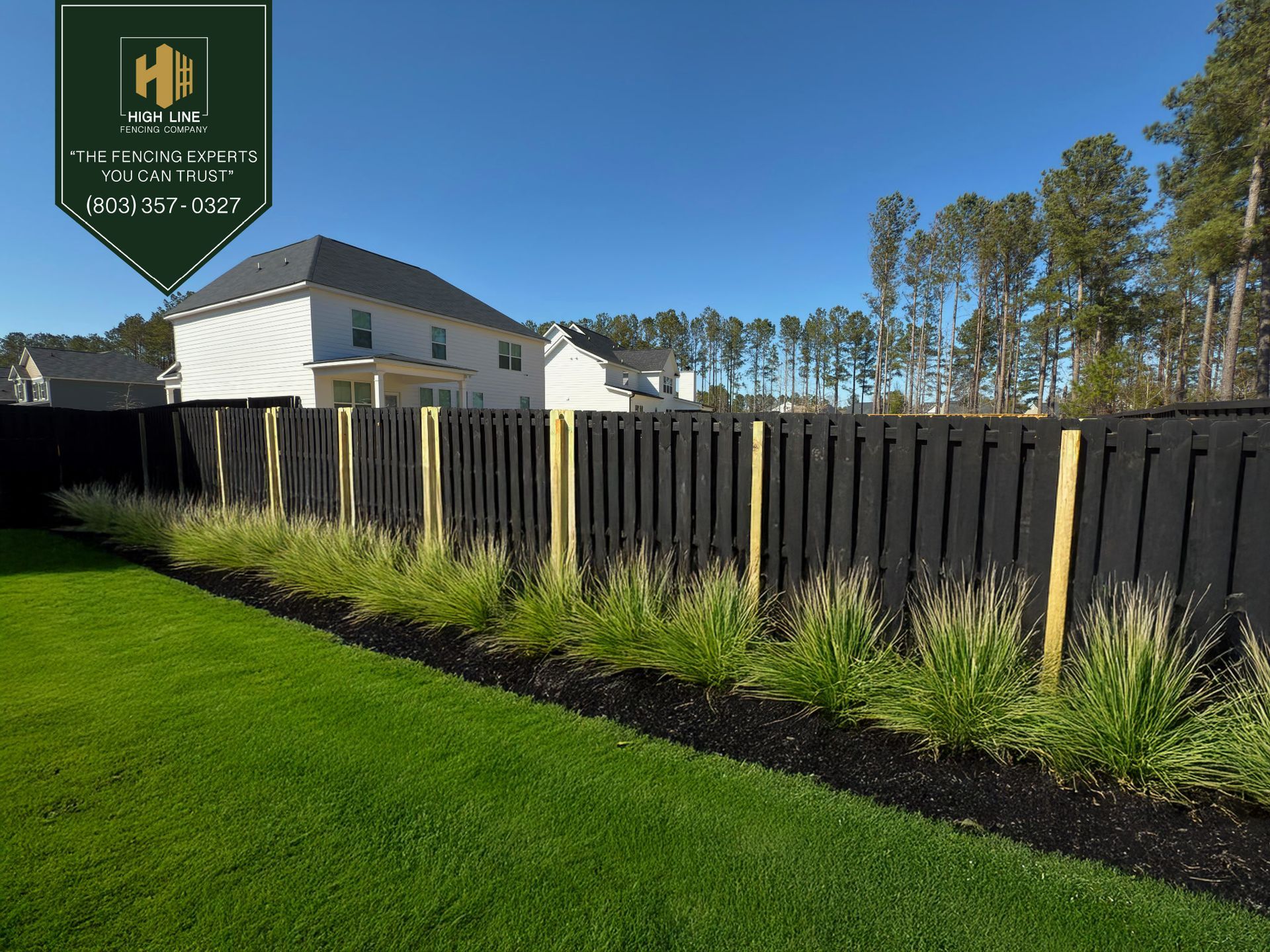 A wooden fence is being built in a backyard.