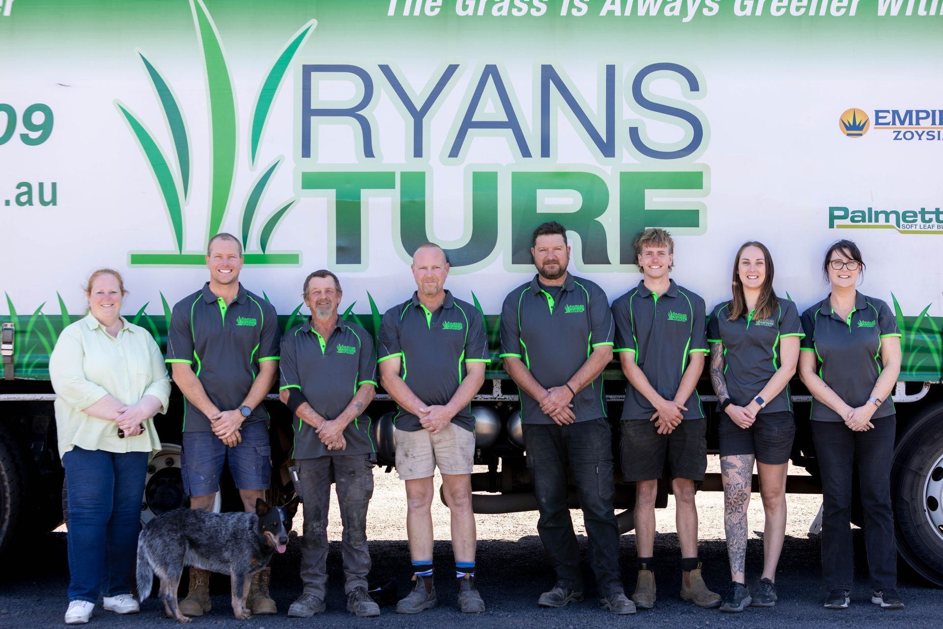 Ryans Turf team stands in front of their truck, wearing grey and green uniforms.