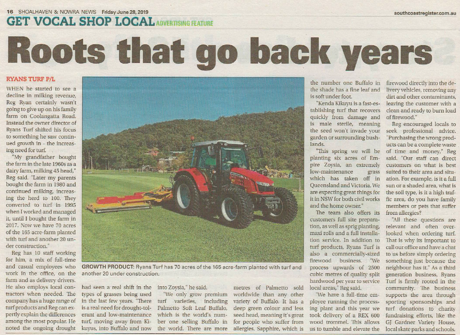 Red tractor mowing green grass in a field.