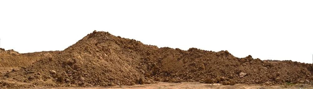 A large pile of brown dirt against a white sky.
