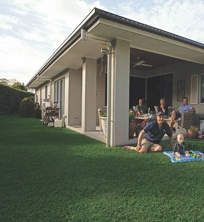 Family gathering outdoors, sitting at a table on a patio