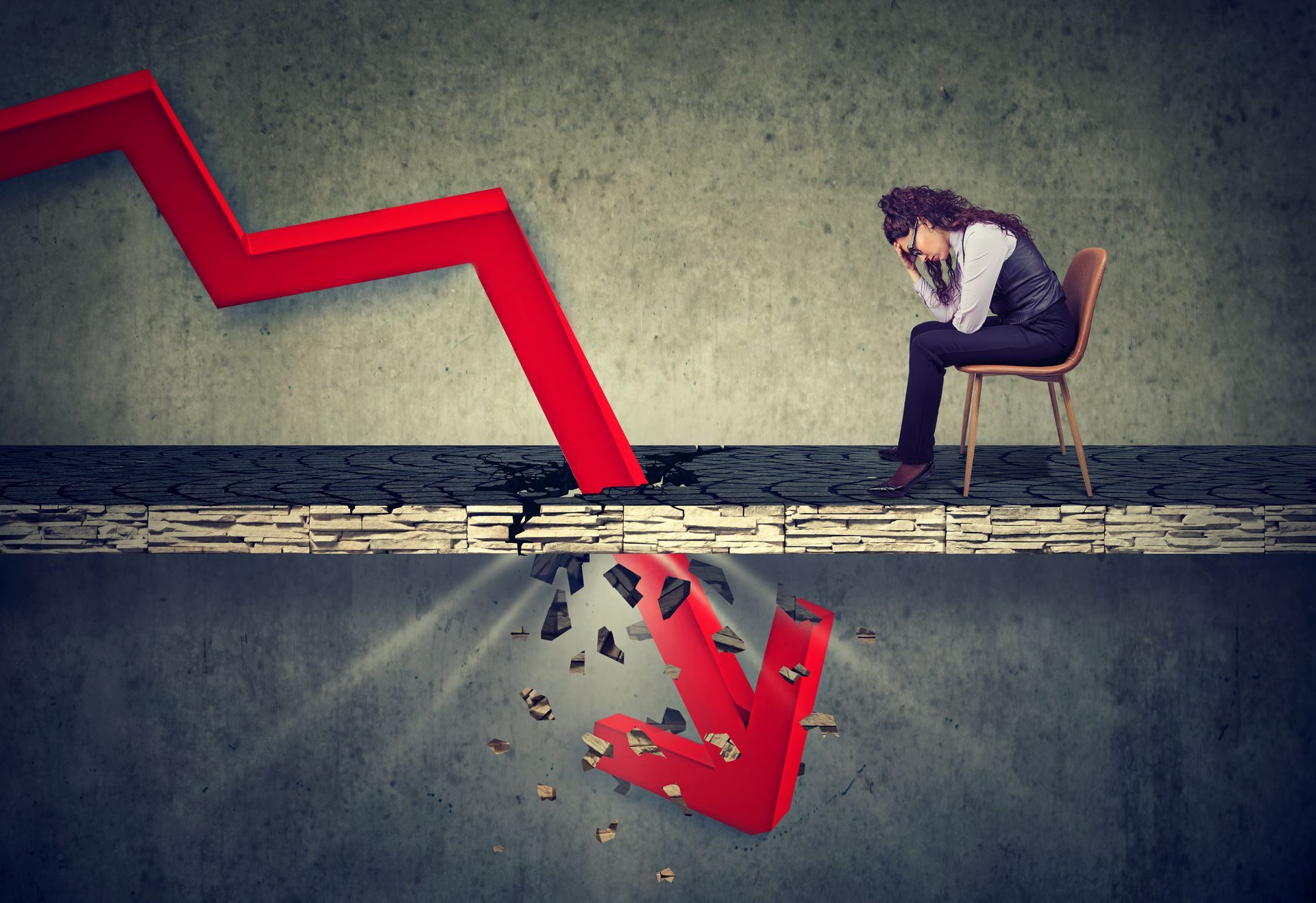 Red downward graph crashing through the floor, woman in distress seated nearby.