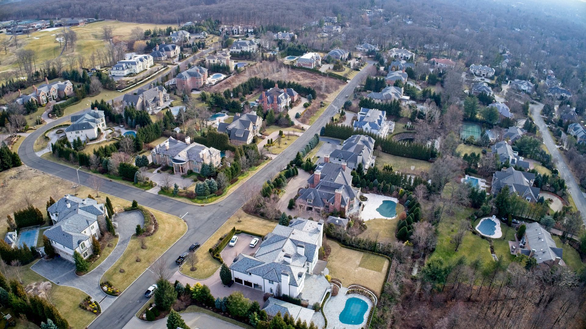 An aerial view of a residential neighborhood with lots of houses and a pool.