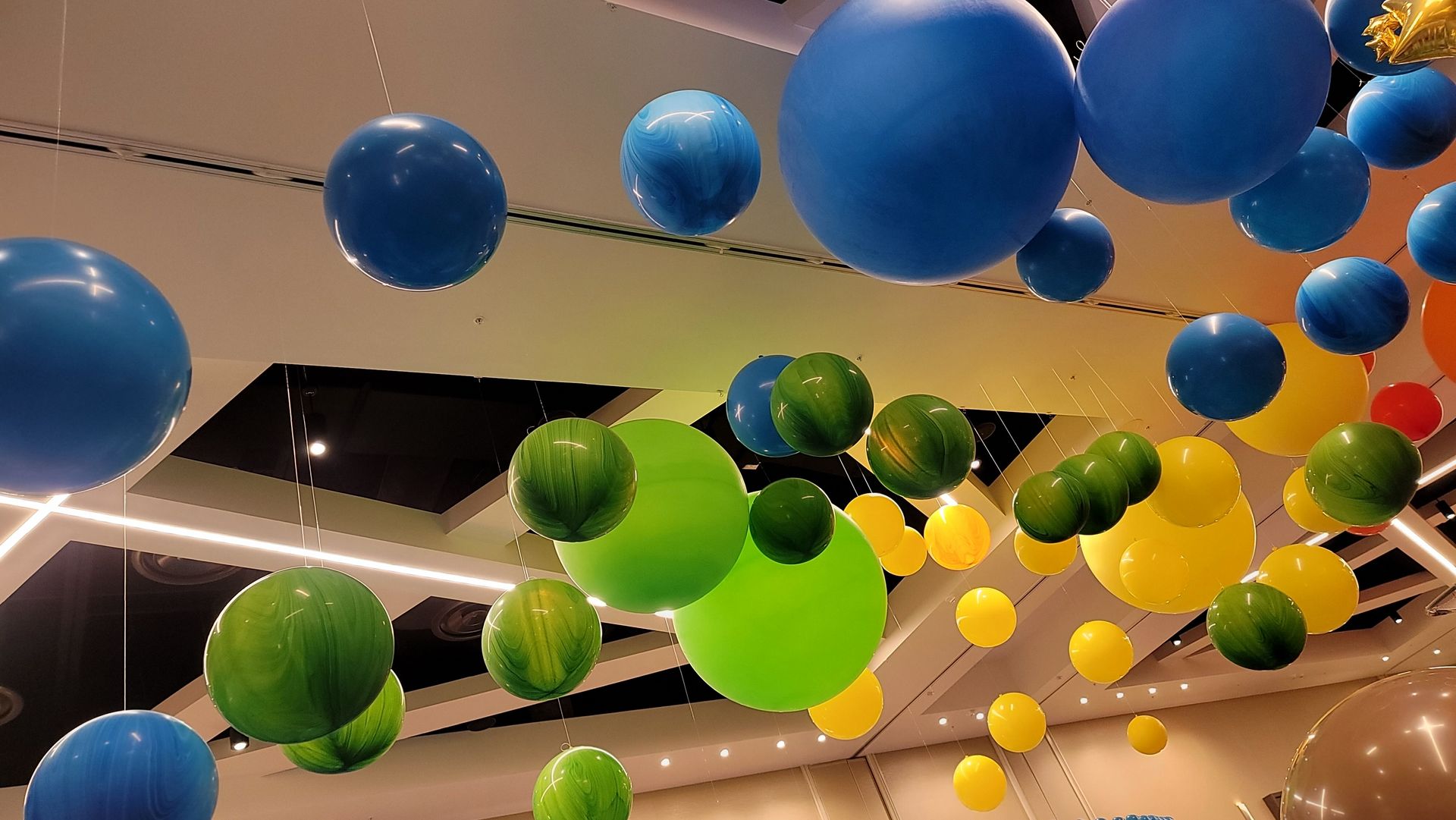 a bunch of balloons are hanging from the ceiling