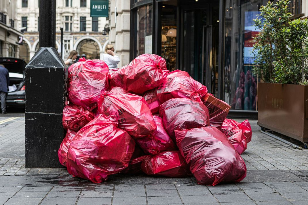 red garbage bags on the city street side red garbage bags on the city street side