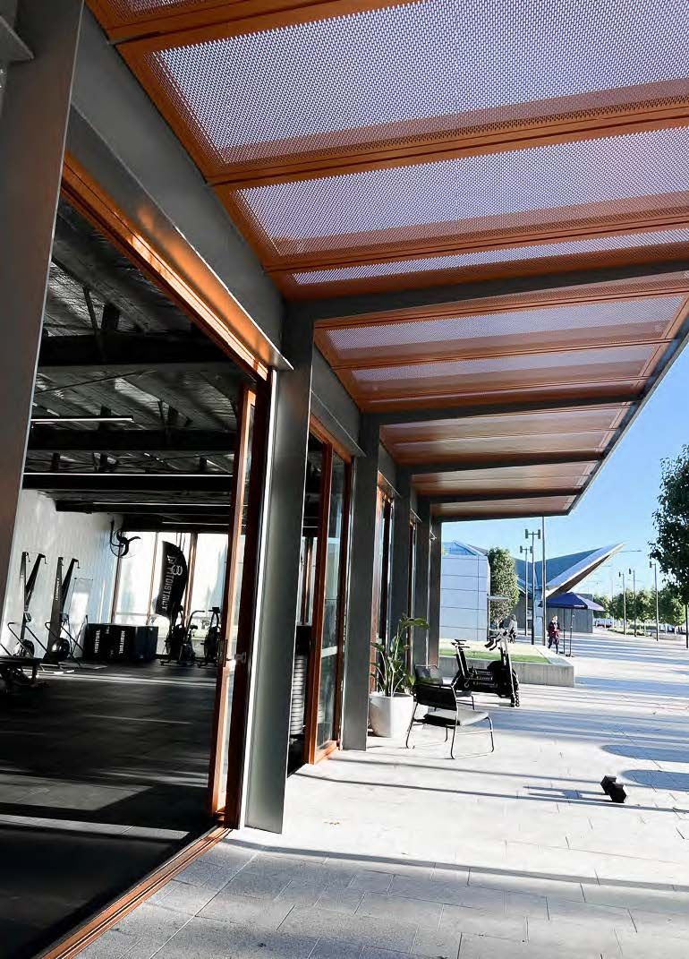 A building with a covered walkway leading to a gym.