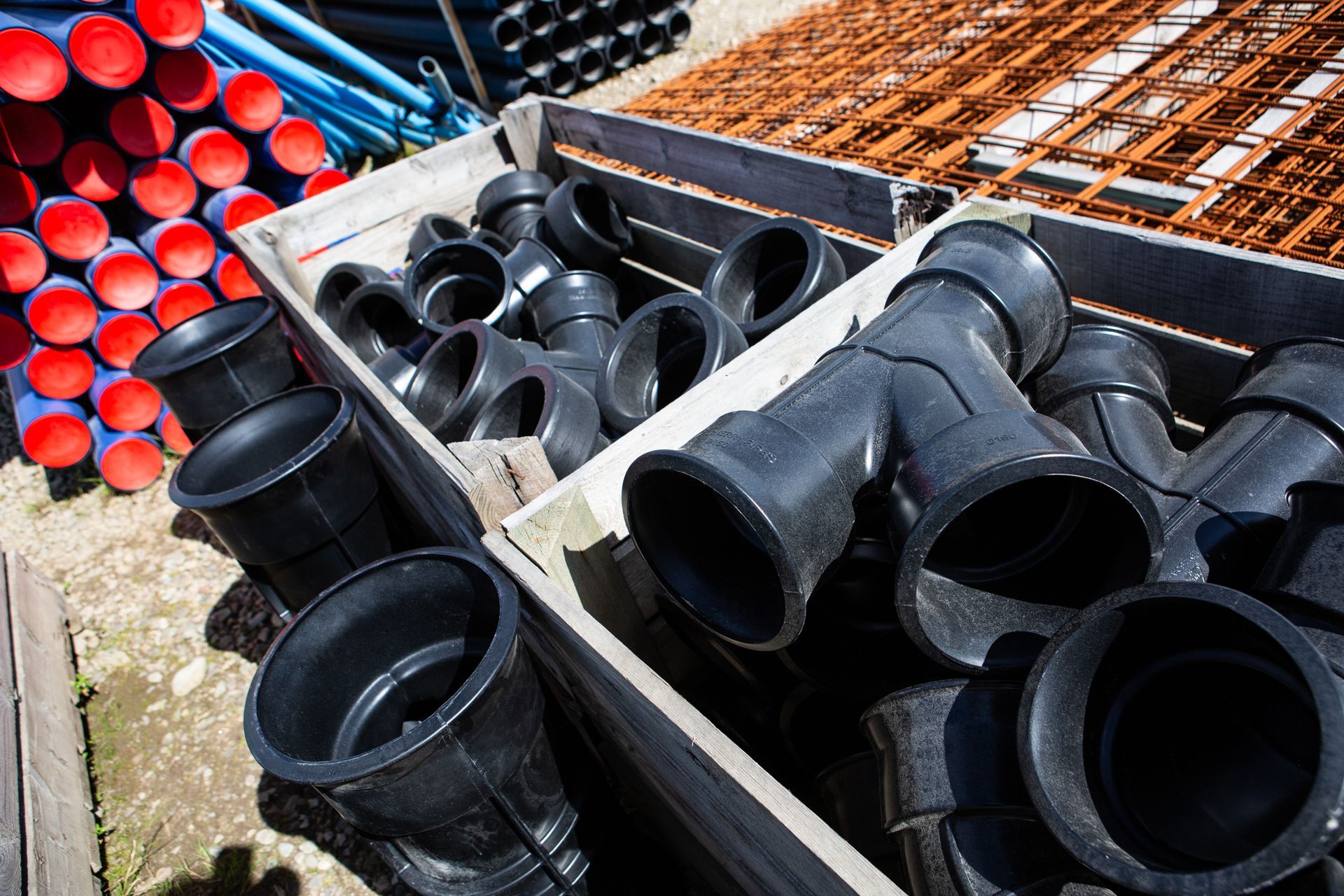 A wooden box filled with black pipes and red pipes.