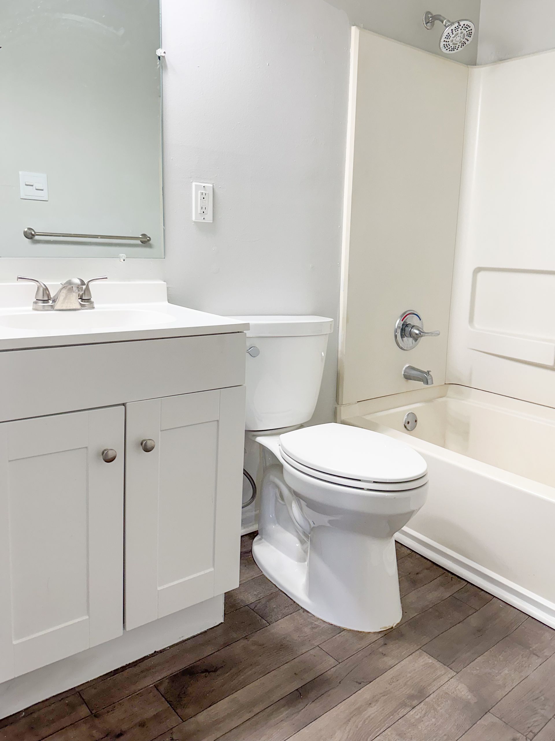 A bathroom with a toilet , sink and bathtub.