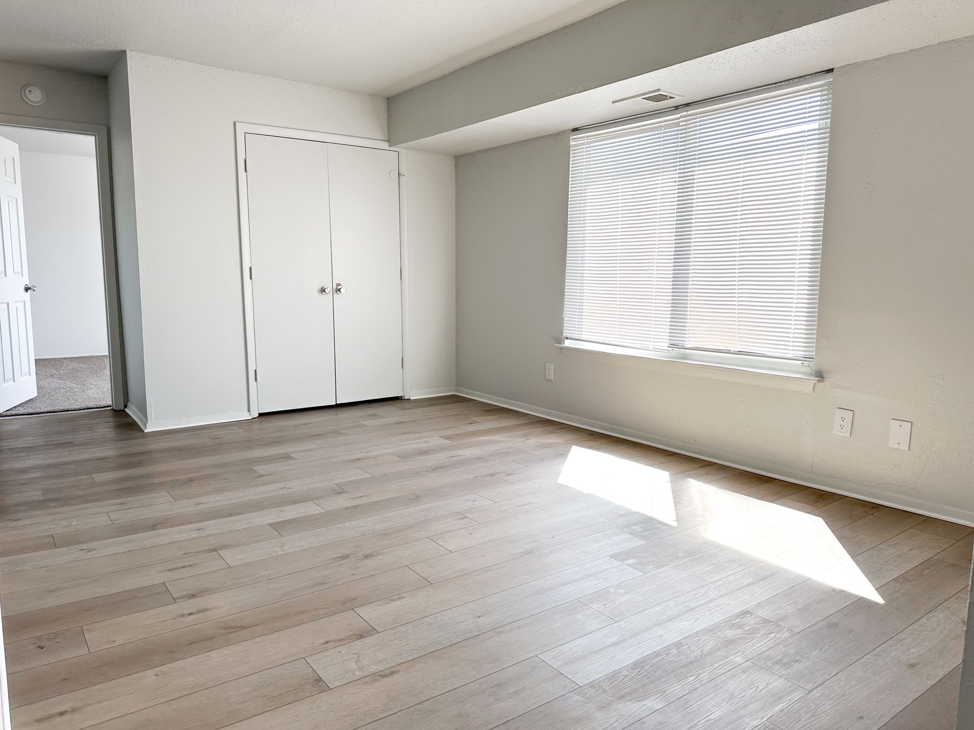 An empty room with hardwood floors and a window