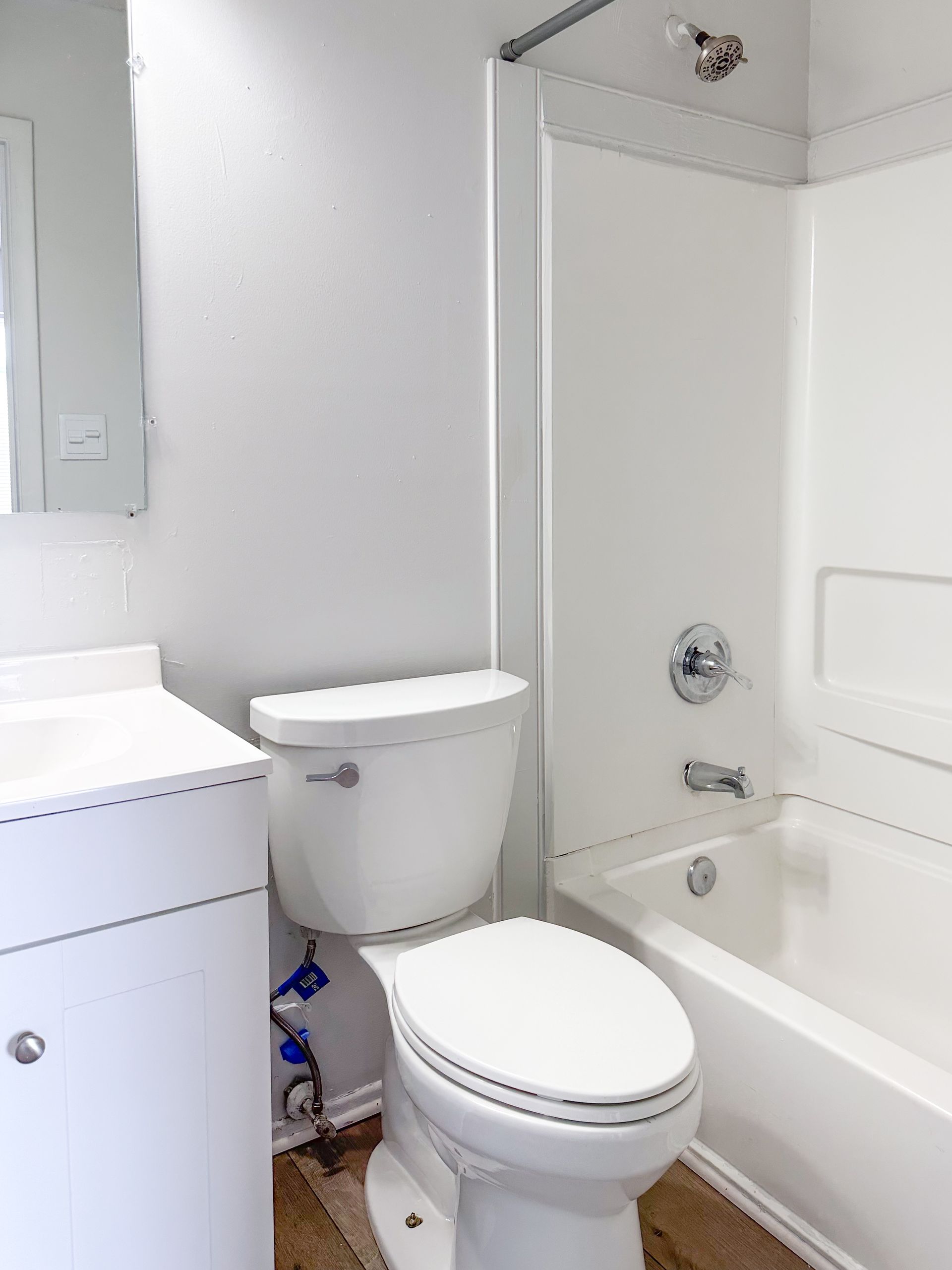 A bathroom with a toilet , sink and bathtub.