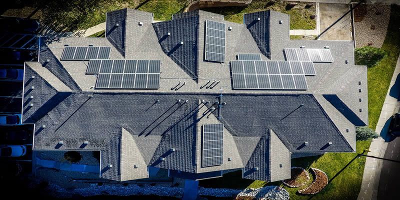 An aerial view of a house with solar panels on the roof.