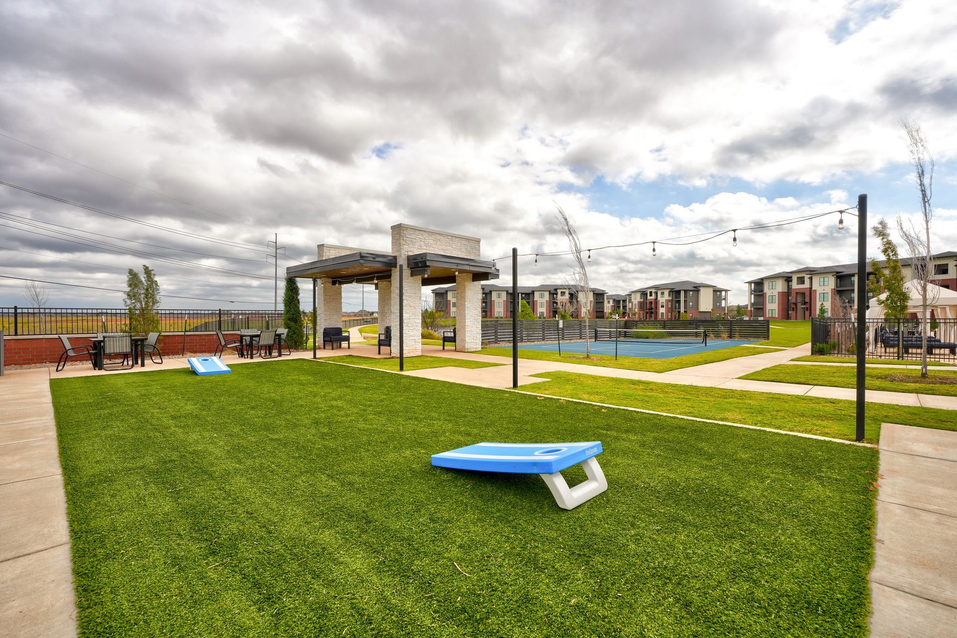 A blue cornhole board is sitting on top of a lush green field.