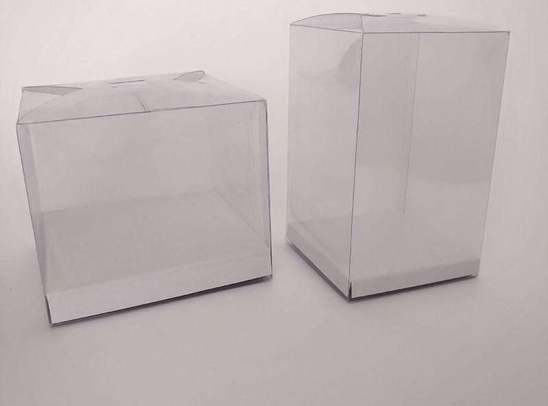 Due scatole di plastica trasparente, una quadrata e una alta, su una superficie bianca.