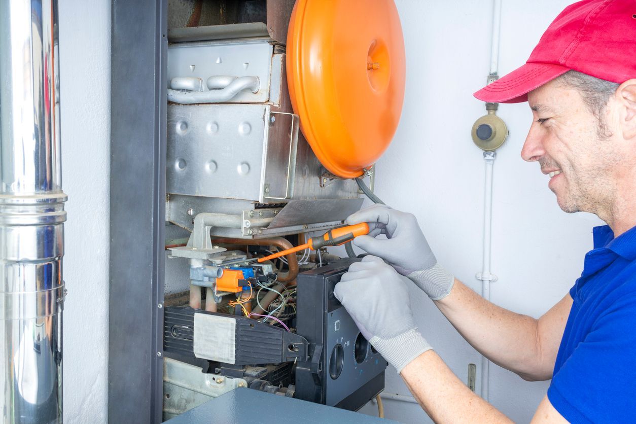 Technician inspecting a heating system for a winter tune-up in Collin County, TX.