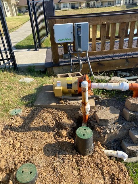 a water pump is sitting in the dirt next to a bench .