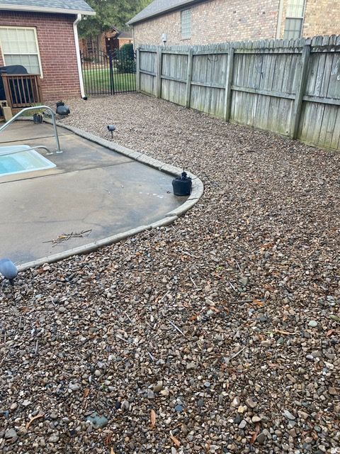 a backyard with a swimming pool and a wooden fence .