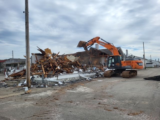 A volvo excavator is being used to demolish a building.