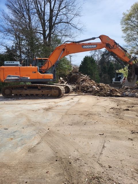 A volvo excavator is being used to demolish a building.