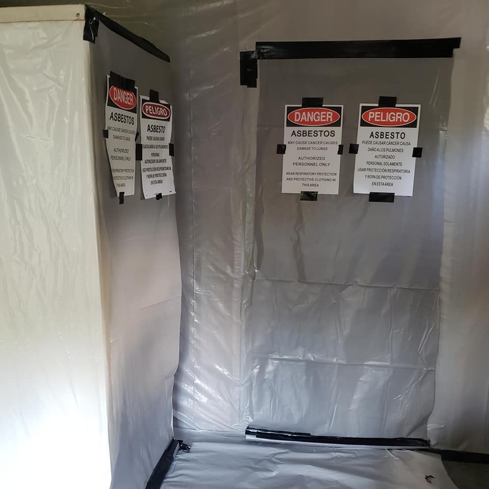 A room with asbestos warning signs taped to the wall