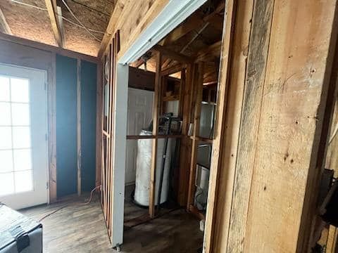 A room in a house under construction with a water heater in it.