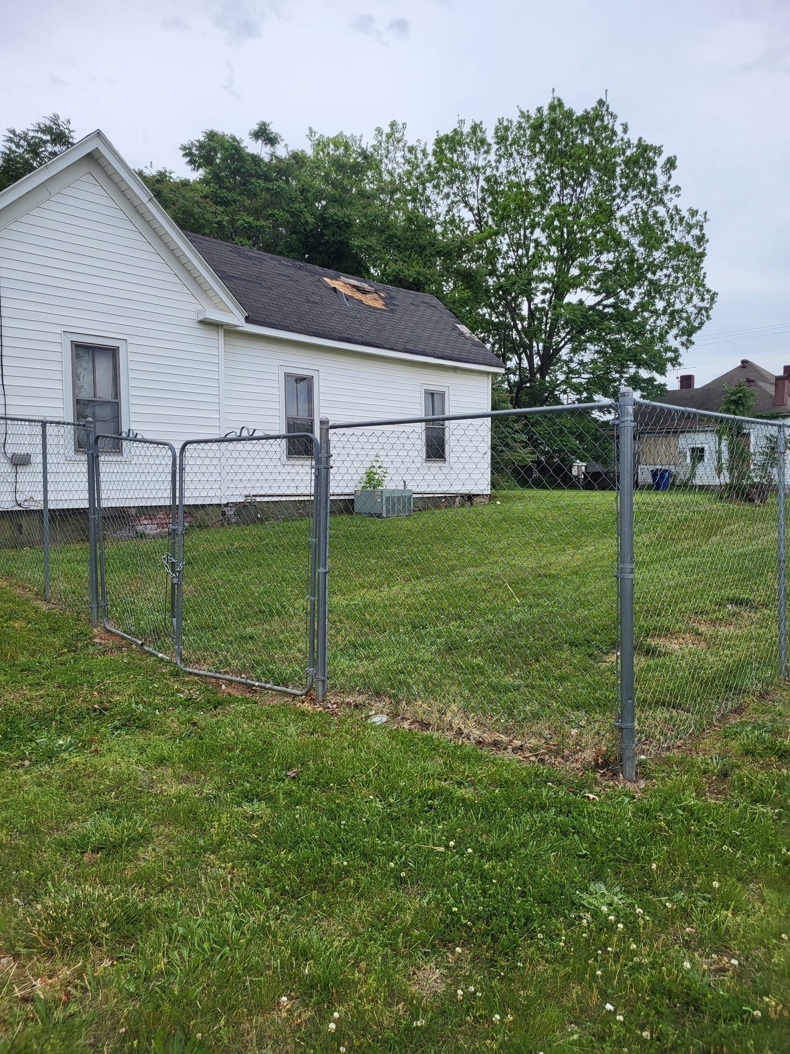 A white house with a chain link fence in front of it.
